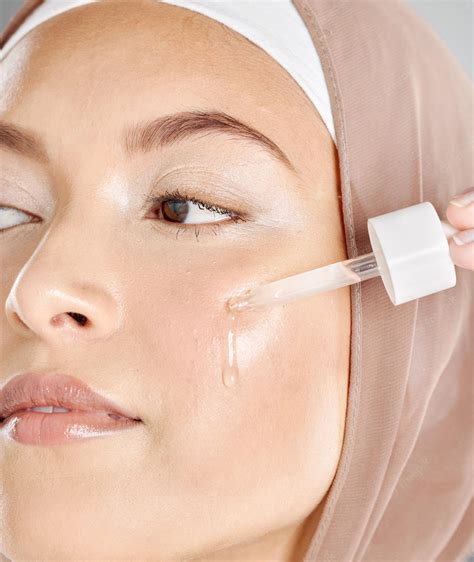 premium photo  young woman applying antiaging facial serum