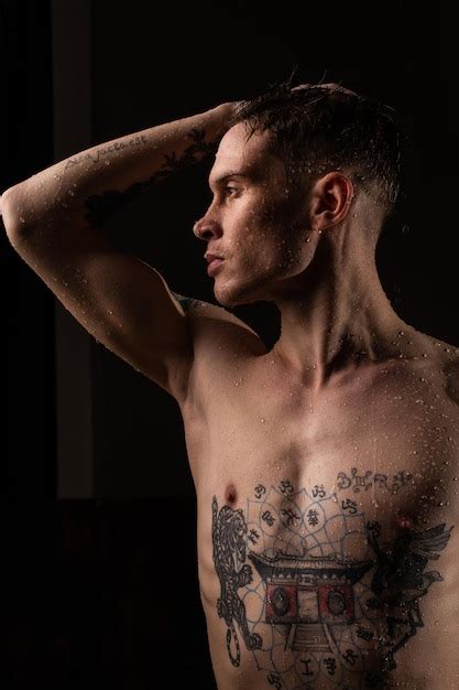 Premium Photo | Sexy healthy tattooed man with water drops on his body