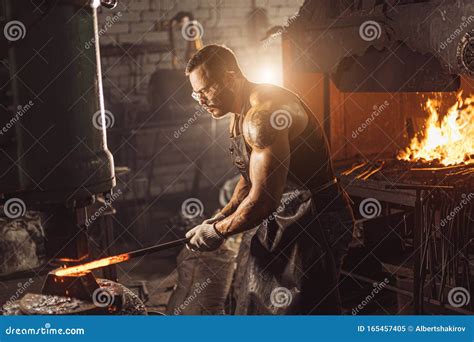 strong muscular blacksmith prepares iron  fire stock image image