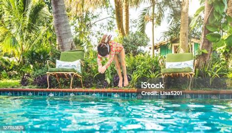 girl  swimsuit dives  backyard pool  summer stock photo
