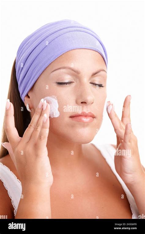 Portrait of attractive young girl applying cream Stock Photo - Alamy