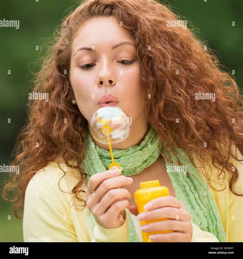 young woman blowing bubbles  park stock photo alamy