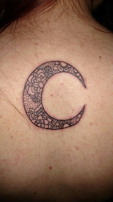 the back of a woman's neck with a crescent tattoo