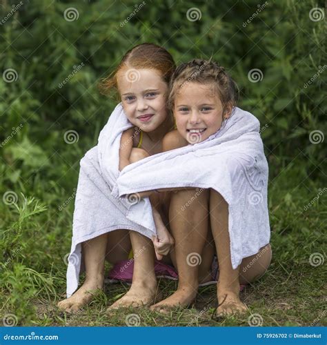 Two Naughty Little Girls Sitting on the Beach in a Towel after a Bathe ...
