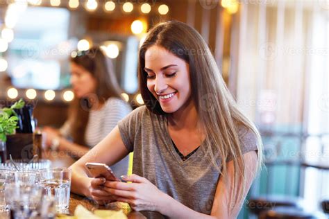 Happy woman texting in restaurant 15862008 Stock Photo at Vecteezy