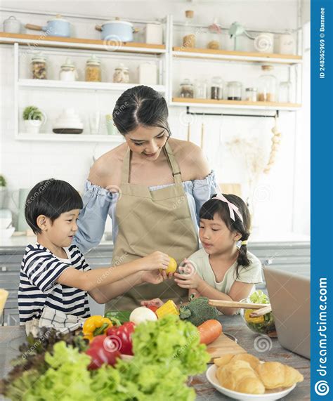 Asian Young Single Mother with Son and Daughter in Kitchen. Enjoy