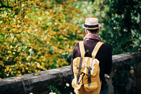 adult, backpack, daylight, fall, fashion, garden, hat, leaves, man