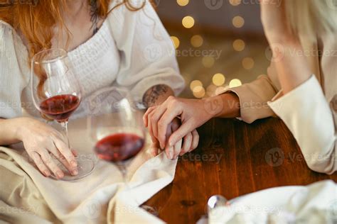 lesbian couple having dinner in a restaurant. Close-up of hands of a