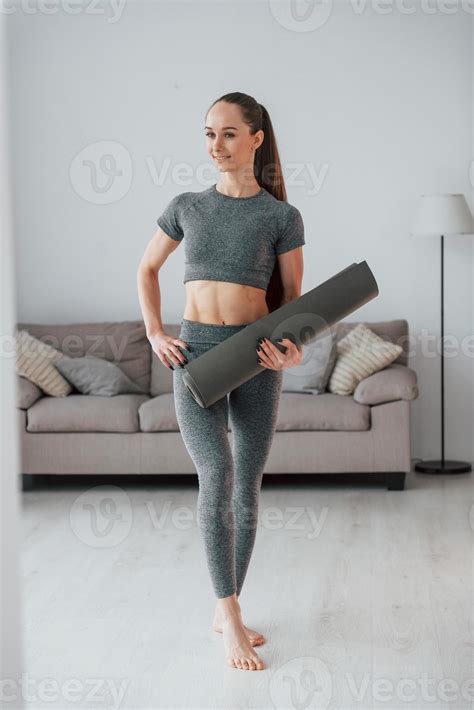 Positive yoga instructor. Young woman with slim body type is at home