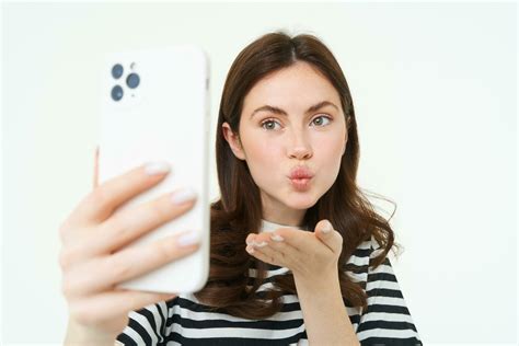 Portrait of young european woman taking selfie on smartphone, holding