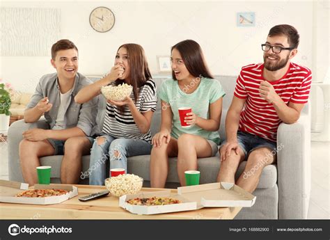 Friends watching TV at home Stock Photo by ©belchonock 168882900