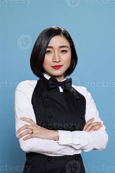 Restaurant woman receptionist wearing uniform smiling while posing with