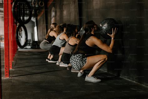 A group of women squatting in a row photo – Crossfit Image on Unsplash