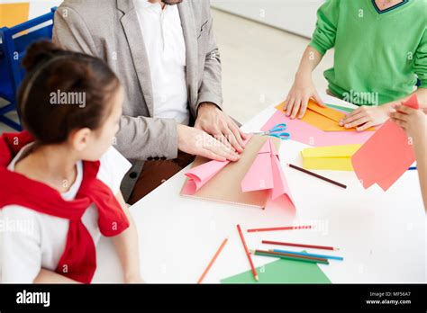 Los niños haciendo aviones de papel con papel de color durante la ...