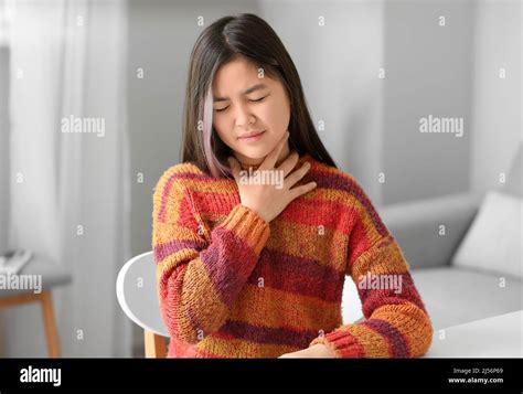 Ill Asian girl with sore throat at home Stock Photo - Alamy