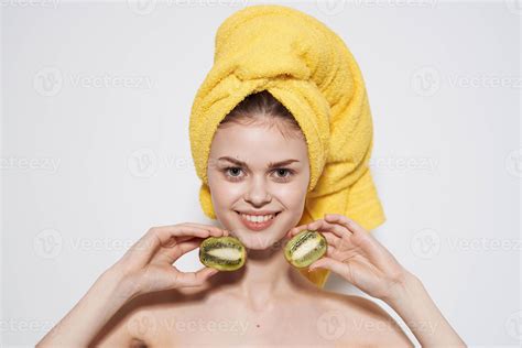 Cheerful woman naked shoulders kiwi in the hands of pure skin natural