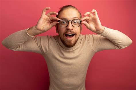Free Photo | Young handsome man in beige turtleneck and glasses looking