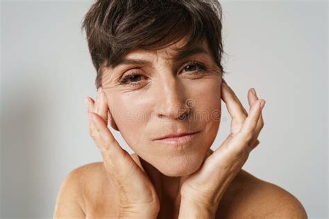 Mature Half-naked Woman Grimacing and Looking at Camera Stock Photo