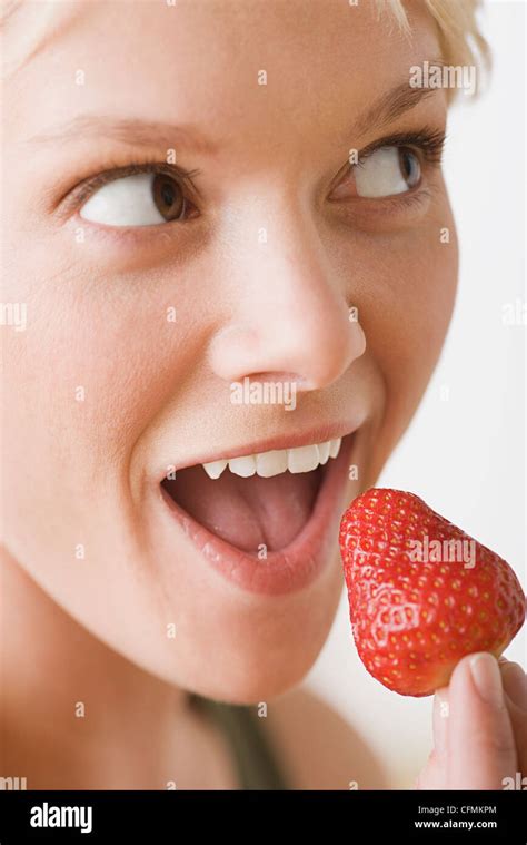 woman eating strawberry stock photo alamy