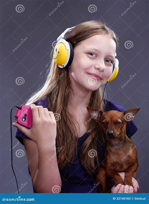 Studio Shot of a Smiling Teen Girl with Headphones and Doggy Stock