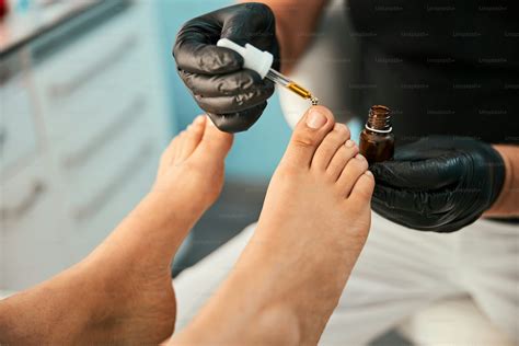 Competent podiatrist using oil for doing foot massage after finishing