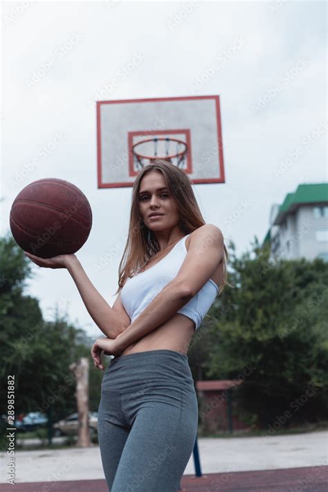 Girl on a basketball court with a ball. Sportswear dressed in leggings ...