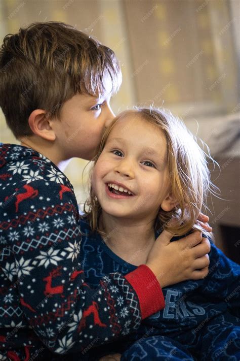 Premium Photo | Two siblings in pajamas sister kiss brother funny emotions