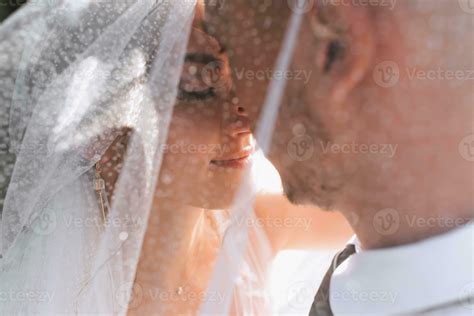 Wedding portrait. The bride and groom covered themselves with a veil
