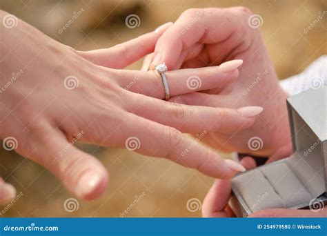 closeup   male hand putting  ring   female  finger