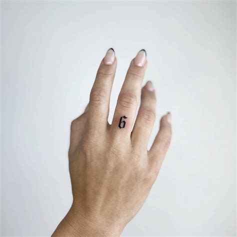 Tattoo of the number "6" located on the finger.