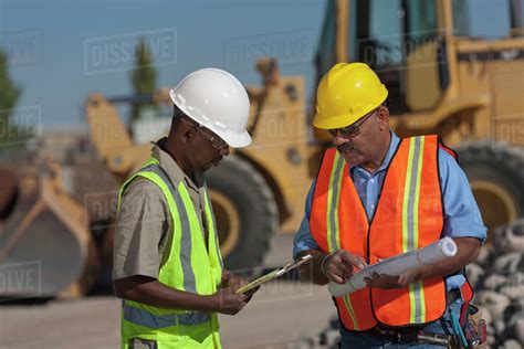 Two construction workers working on building site - Stock Photo - Dissolve
