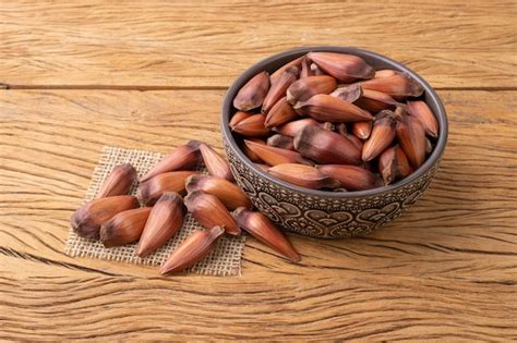 Premium Photo | Pinions or pine tree seeds on a bowl over wooden table