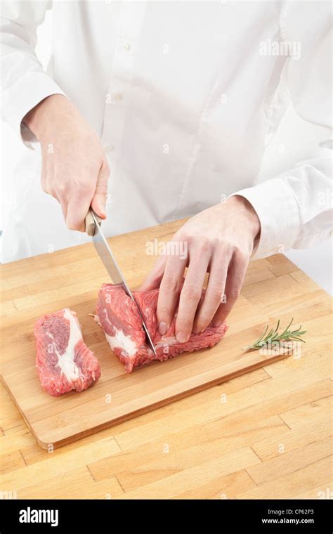 man cutting meat  chopping board stock photo alamy