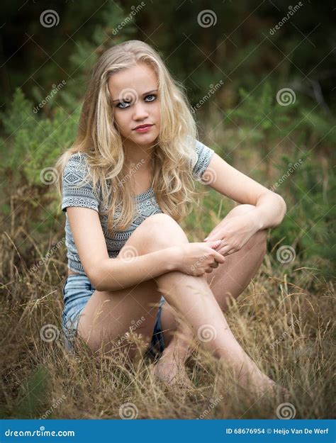 Pretty Blond Teenager Sitting in the Grass Stock Photo - Image of blue