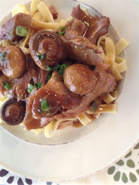 a white plate topped with pasta and meat covered in sauce