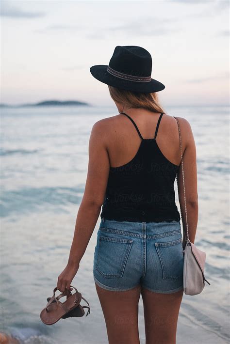 "Back View Of A Woman Walking On The Beach At Sunset" by Stocksy