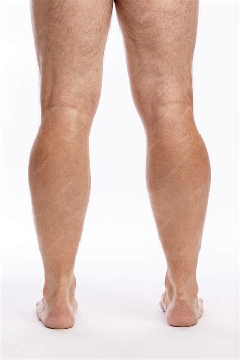 Descubra as pernas masculinas peludas em uma parede branca. fechar-se