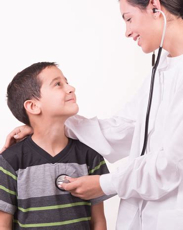Woman Doctor Dressed In White Hugging A Child Stock Photo - Download