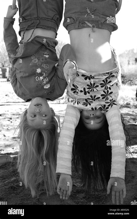 Girls hanging upside down on outdoor jungle gym Stock Photo: 16139564