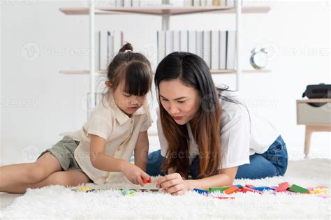 asian mother teaching her young child to play puzzles at home 3154800