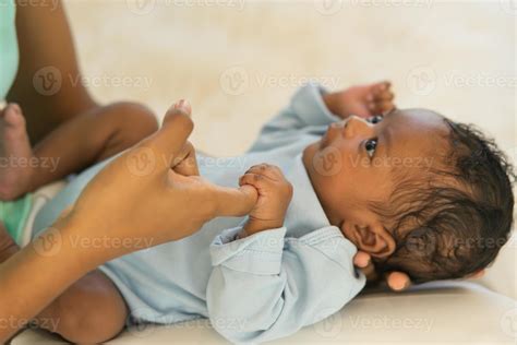 African Newborn baby one-month-old holding fingers mother's hand, Smile