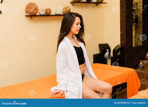 An Attractive Latin American Woman Lying Down on a Massage Bed at a Spa 