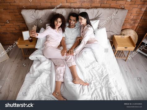 threesomes   men bed  woman  royalty  images stock