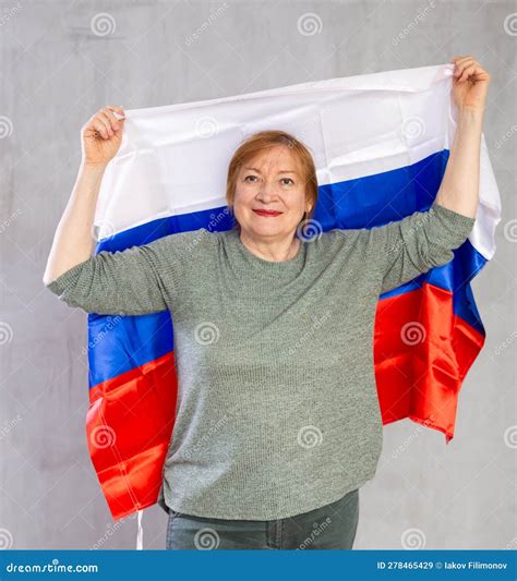 Cheerful Senior Woman Standing Confidently with Russian Flag Stock