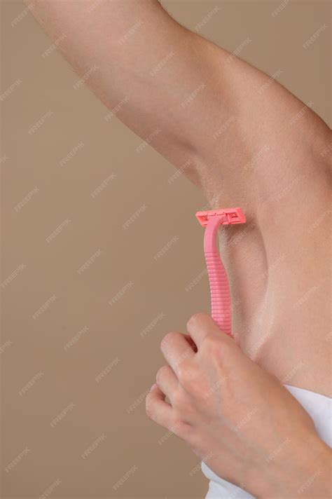 Premium Photo | Shaving. close up of a woman shaving underarms area
