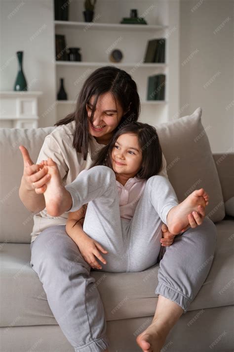 Free Photo | Mother tickling kid on couch full shot