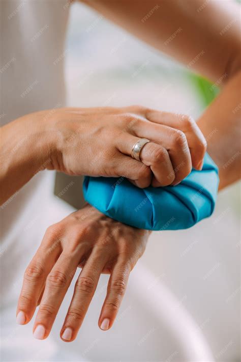 Wrist pain treatment woman holding ice bag compress on a painful wrist