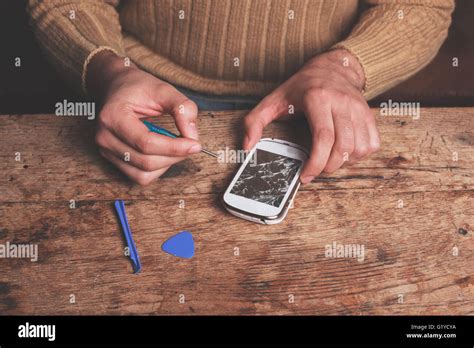 A technician is fixing and replacing the broken screen on a smart phone ...