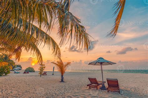 Sunset beach. Beautiful tropical island shore, two sun beds lounger