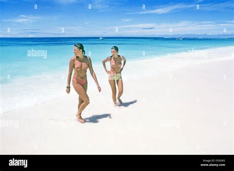 Two young women nude on a topless beach in the Seychelle Islands Stock